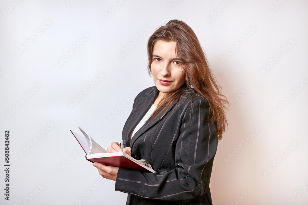 Beautiful businesswoman makes a note in a notebook. Beautiful businesswoman makes a note in a notebook.