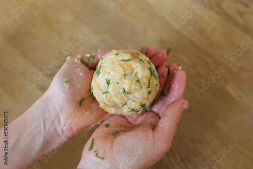 Hands holding Semmelknödel. Preparing austrian traditional dumplings with parsley.