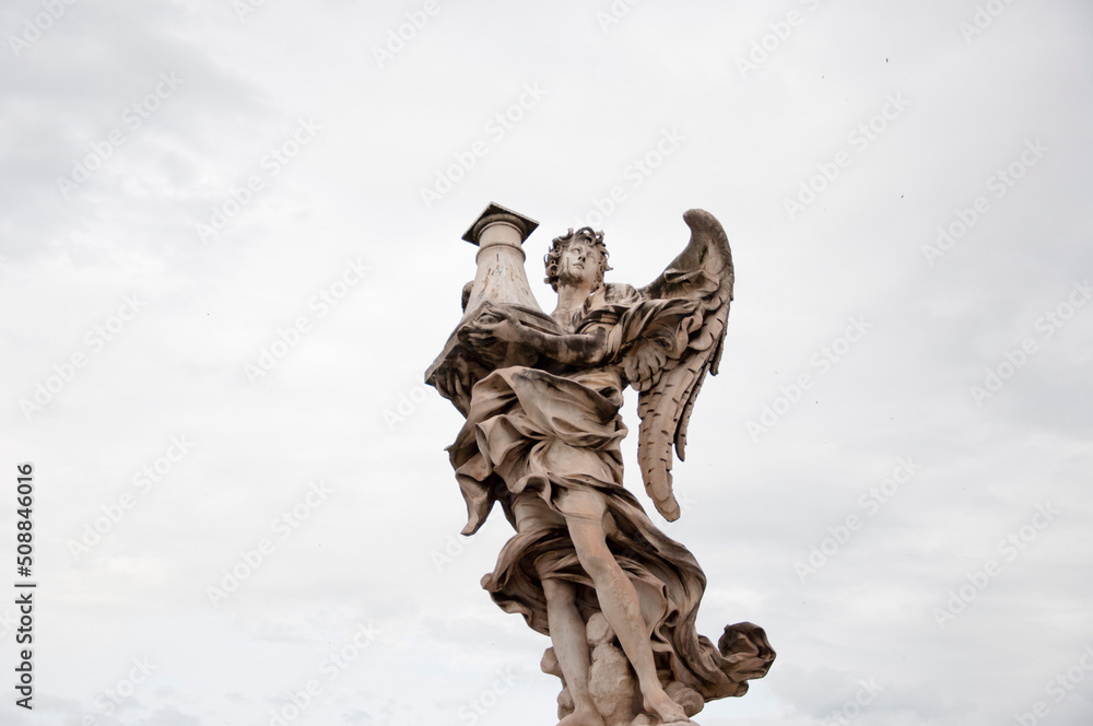 Fototapeta premium Angel with column ancient marble statue architectural sculpture historical landmark in Rome, Italy