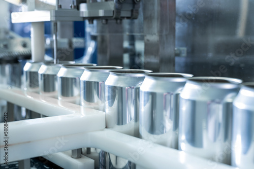 Empty new aluminum cans for drink process in factory line on conveyor belt machine at beverage manufacturing. food and beverage industrial business concept. High quality photo