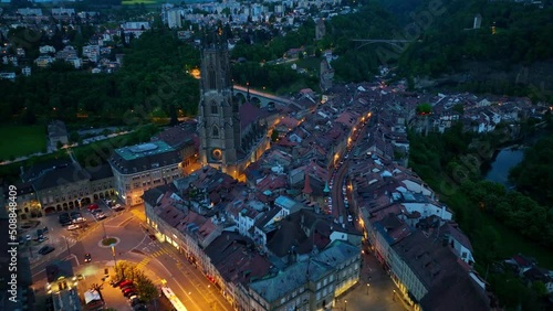 flying above historic Swiss town of Fribourg at night, aerial view of Fribourg in Switzerland with night illumination, tourism in Switzerland concept photo