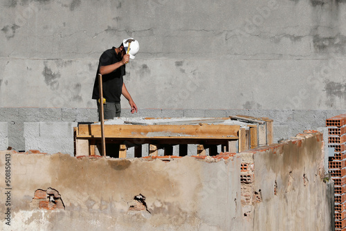Carpenter construction worker. Workman renovating roof of building. House repair under construction. Man at work on roofing