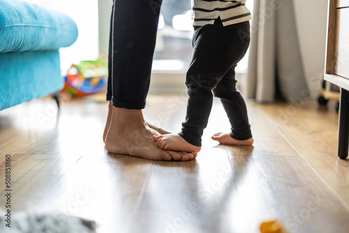Baby son standing on mothers feet  © pikselstock