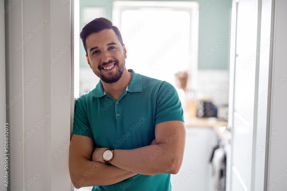 Smiling man standing in the doorway to the kitchen
Smiling man standing in the doorway to the kitchen