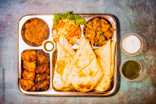 tikka boti seekh kabab platter with pulao, roti, lime and salad in a dish top view of middle eastern barbeque dish photo