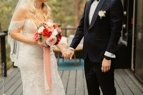 Elopement wedding couple holding hands on an outdoor patio