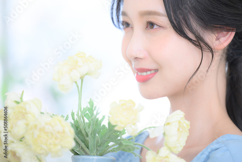 Beautiful Asian woman holding a bouquet of flowers, profile.