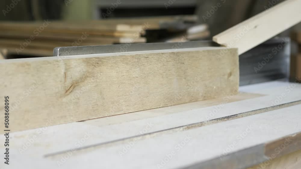 Close-up: a carpenter in his workshop saws a wooden board with a circular saw, makes furniture parts in natural light. A carpenter works with wood. Construction Tools For Home Repair.Carpentry tools