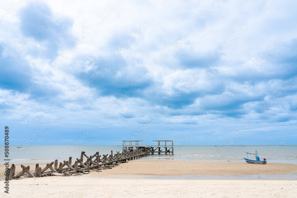 Old port for fishing boats, dilapidated and small fishing boats on the sandy beach sea, rain cloudy sky in the background, Pranburi,Prachuap Khiri Khan Thailand Old port for fishing boats, dilapidated and small fishing boats on the sandy beach sea, rain cloudy sky in the background, Pranburi,Prachuap Khiri Khan Thailand