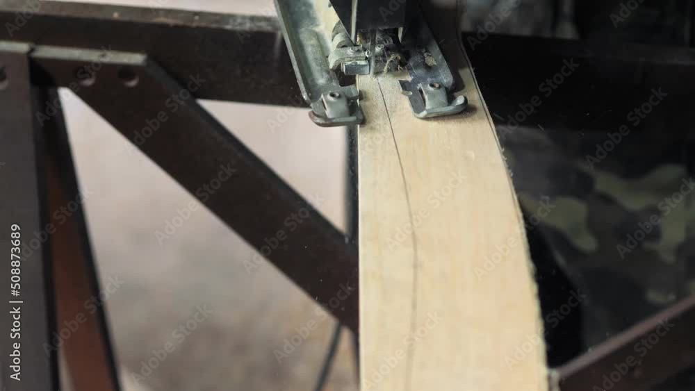 Close-up: a carpenter in his workshop saws a wooden board with an electric jigsaw, makes furniture parts in natural light. A carpenter works with wood, processing it.Construction Tools For Home Repair Close-up: a carpenter in his workshop saws a wooden board with an electric jigsaw, makes furniture parts in natural light. A carpenter works with wood, processing it.Construction Tools For Home Repair