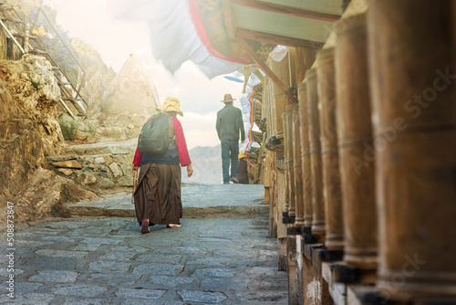 Tibetan pilgrims and Prayer wheels along a pilgrim route in Shigatse, Tibet (Tashilumpo Monastery) photo