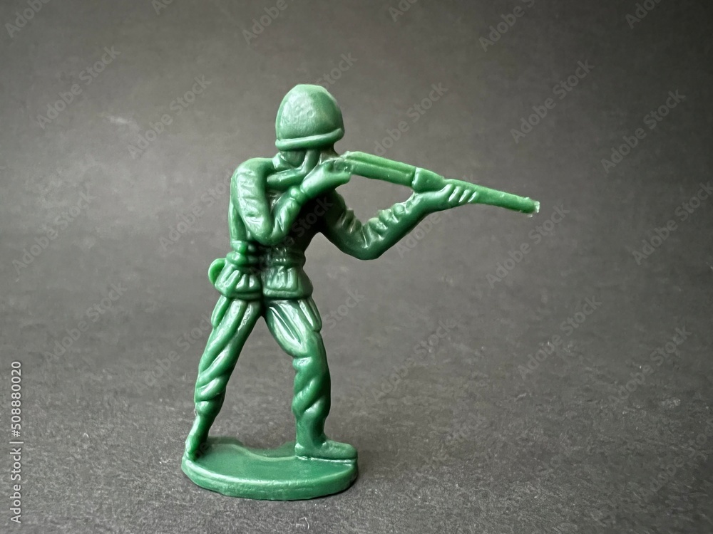 敵へ向かって銃を構える兵士の人形(黒背景)、戦争イメージ 敵へ向かって銃を構える兵士の人形(黒背景)、戦争イメージ