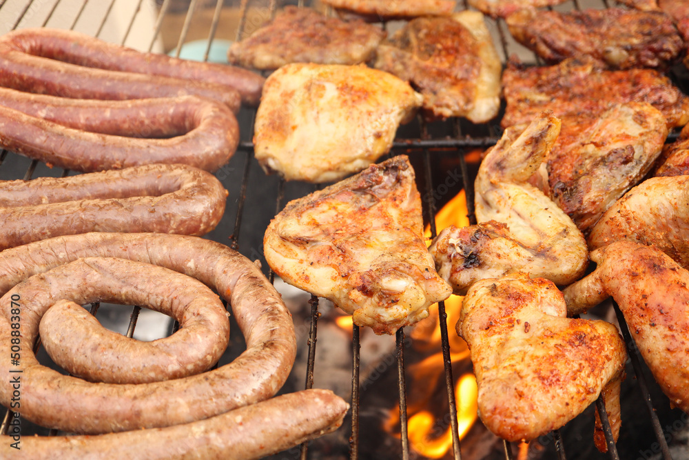 Braaied meat on the grill. South African braai with chicken, chops, boerewors lamb chops