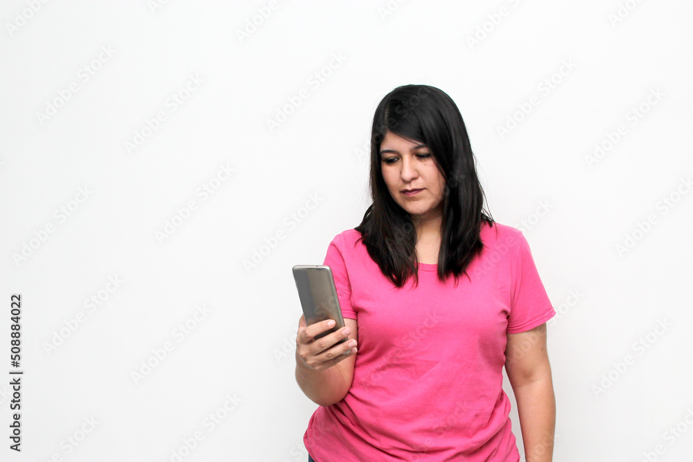 Latin adult woman uses her cell phone to make a video call with expressions of emotion, happiness and disgust wearing a pink shirt
Latin adult woman uses her cell phone to make a video call with expressions of emotion, happiness and disgust wearing a pink shirt