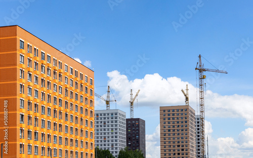 Tower cranes on the residentiam building costruction site on blue sky