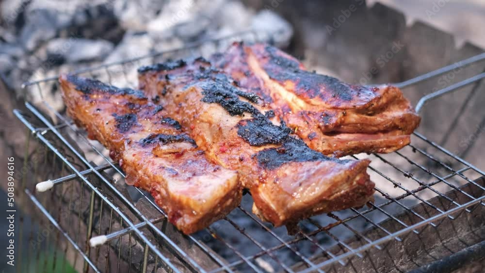 delicious beef or pork ribs frying on a charcoal grill delicious beef or pork ribs frying on a charcoal grill
