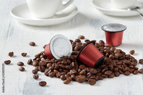 Closeup of roasted coffee beans and coffee capsules photo