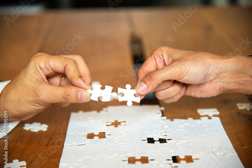 Hands of business people holding jigsaw Business Concept