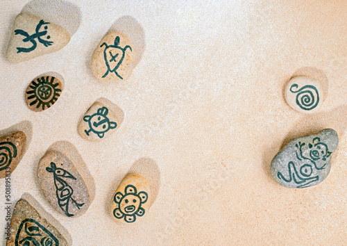 Fotografia Stones with hand-drawn taino petroglyphs symbols, craft with children for Hispan