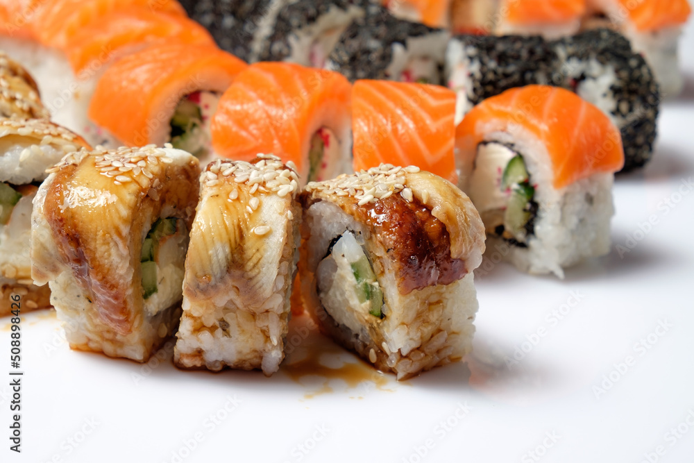 Tasty sushi and sushi roll set with wasabi and ginger on white background. Vegan sushi rolls. Seafood. Tasty sushi and sushi roll set with wasabi and ginger on white background. Vegan sushi rolls. Seafood.