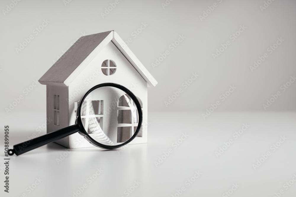 Magnifying glass and house model. House selection and search, real estate concept - obrazy, fototapety, plakaty 