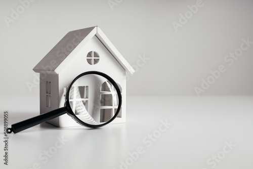Magnifying glass and house model. House selection and search, real estate concept