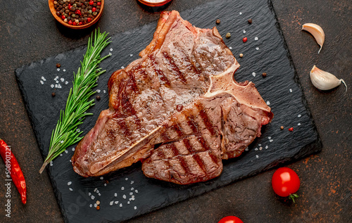 grilled T-bone steak or porterhouse Steak with herbs and salt on stone background