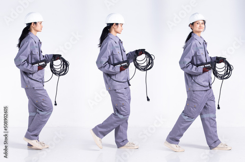 Full length 20s young Mix Race engineer electrician Woman, walking forward left right