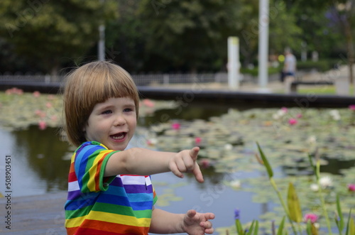 A little positive boy in nature, in the garden, by the pond. child in the park