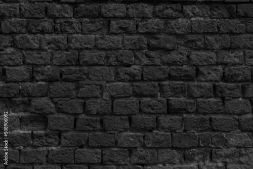 Black brick wall of the building. Designer building background.