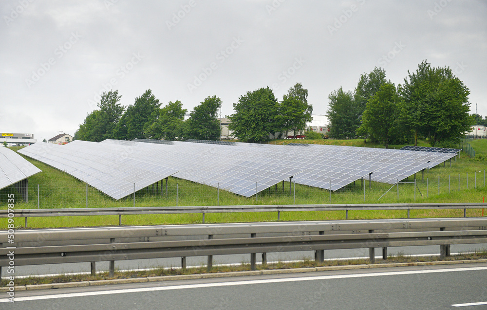 Obraz premium A lot of solar panels on the side of the road next to an autobahn highway in Bavaria, Germany. Solar energy is an green eco way to produce electrical power.