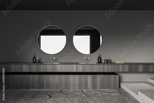 Grey bathroom interior with sink and mirror, accessories on dresser