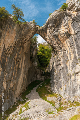 landscape of a natural arch-shaped bridge formed between two mountains © victor