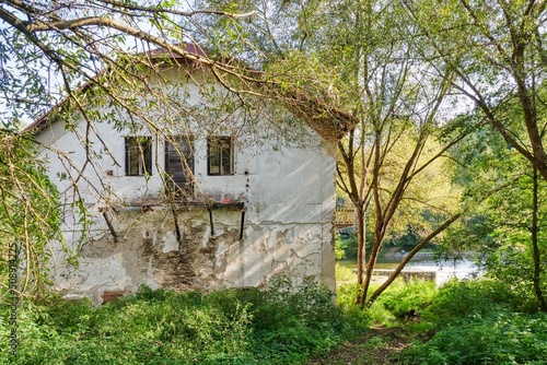 Half-dilapidated house  in an overgrown garden on the banks of the river Lužnice photo