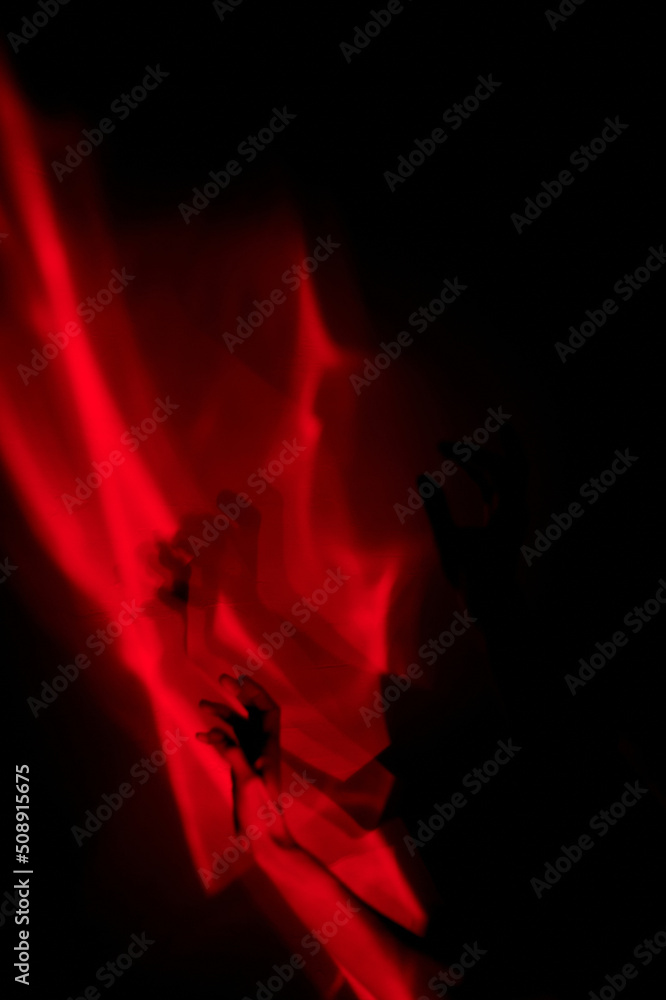 Fototapeta premium Hands in red light. Abstraction. Shadow theatre, hallucinations.