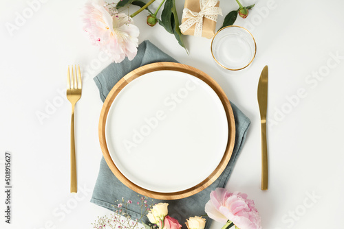 Foto Beautiful table setting with golden cutlery and peony flowers, mock up