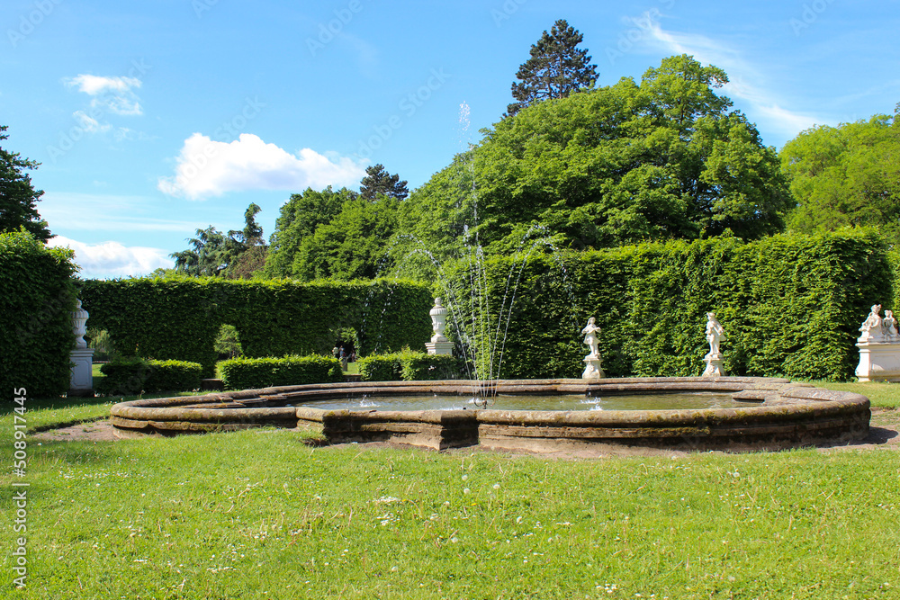 green park with fountain and blue spring sky