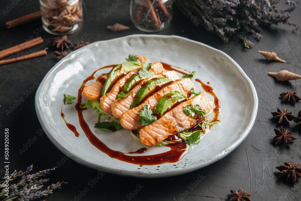 Plate of gourmet salmon and avocado appetizer with sauce