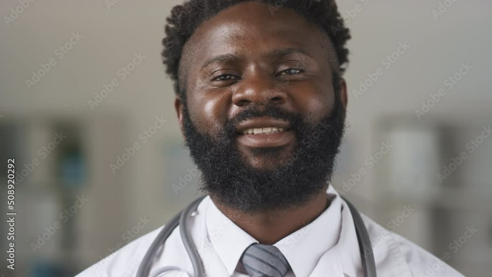 Portrait of African American doctor wearing white coat wearing protective mask looking at camera Portrait of African American doctor wearing white coat wearing protective mask looking at camera