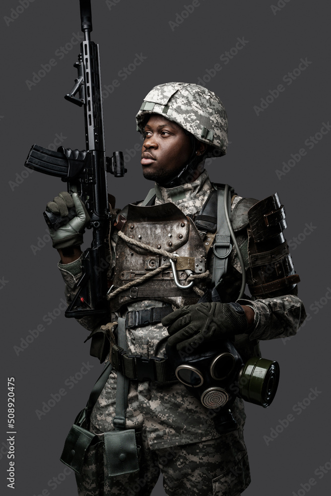 Portrait of african military man dressed in modern camouflage uniform holding rifle. Portrait of african military man dressed in modern camouflage uniform holding rifle.