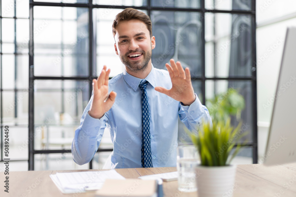 Smiling young business man having video call in office. Smiling young business man having video call in office.