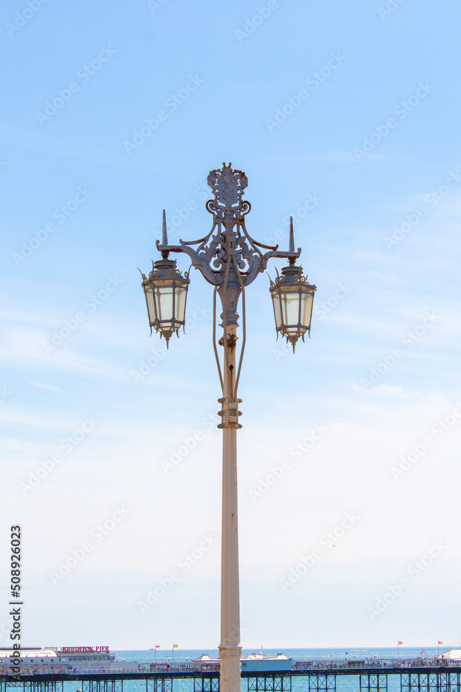 Brigthon light post with pier in the backgrounf