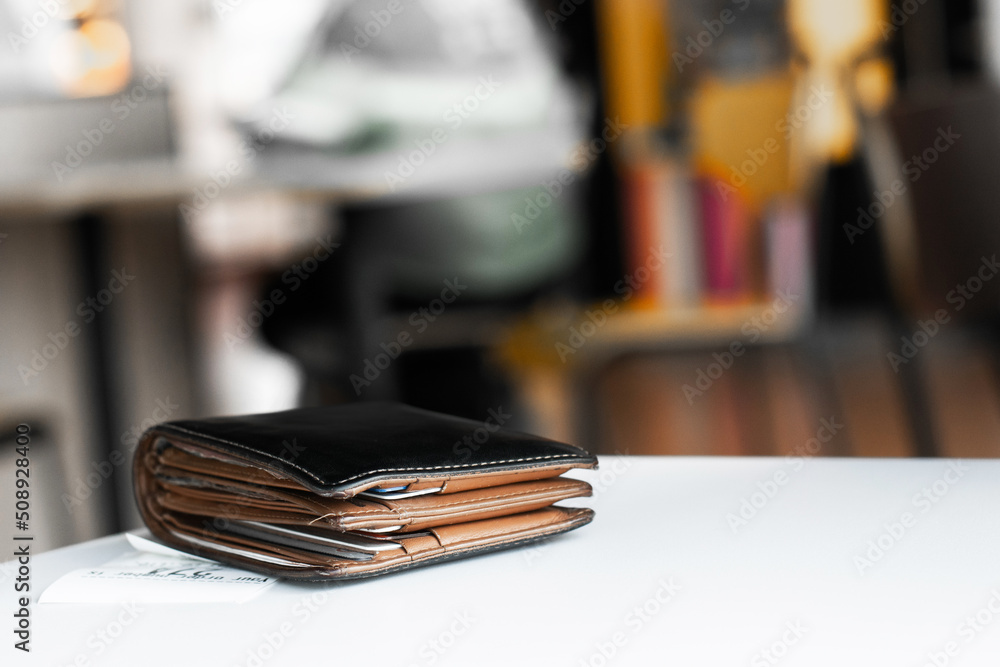 Soft tone of Money and credit card in a leather wallet on wooden table and bill slip background