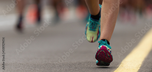 Marathon running race, people feet on city road, runners run urban marathon in the the city