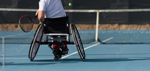 Men on wheelchair playing tennis on tennis court