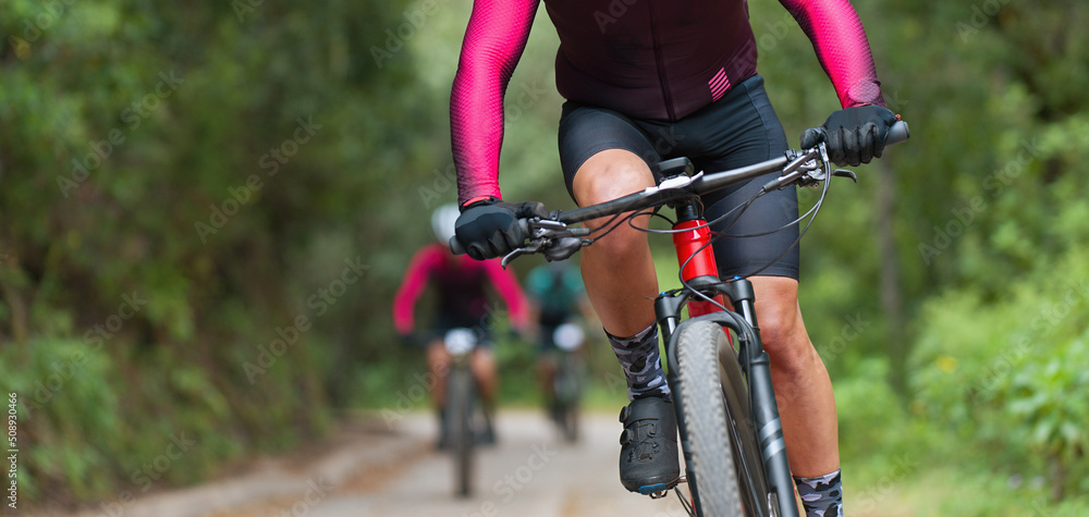 Mountain bikers riding on bike singletrack trail, mountain bike race Mountain bikers riding on bike singletrack trail, mountain bike race
