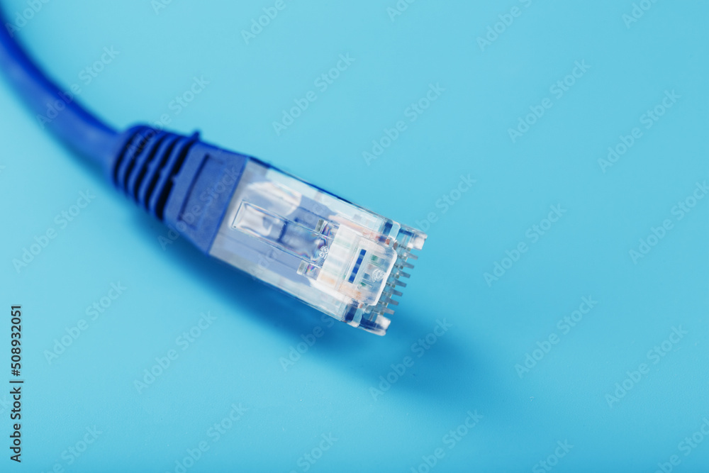 Ethernet Cable connector Patch cord cord close-up on a blue background with free space Ethernet Cable connector Patch cord cord close-up on a blue background with free space