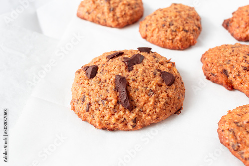 Homemade oat cookies with chocolate over white background. Rustic snack for a healthy lifestyle.