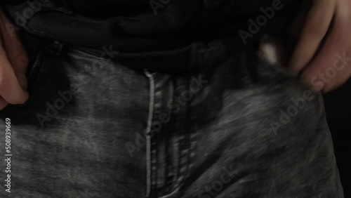 A man caressing his crotch (the part of the body where the legs join at the top) with his hands and offering money from his wallet, making a vulgar unsolicited sexual offer.
