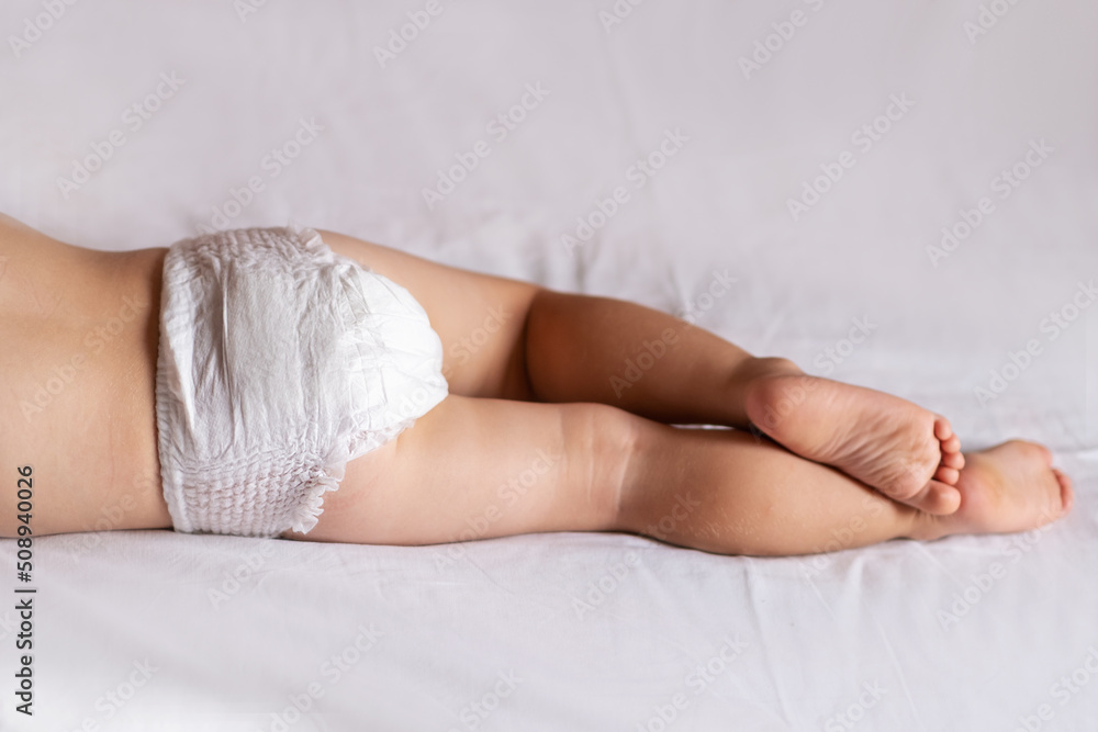 The boy sleeps in a diaper. Closeup of baby's feet The boy sleeps in a diaper. Closeup of baby's feet